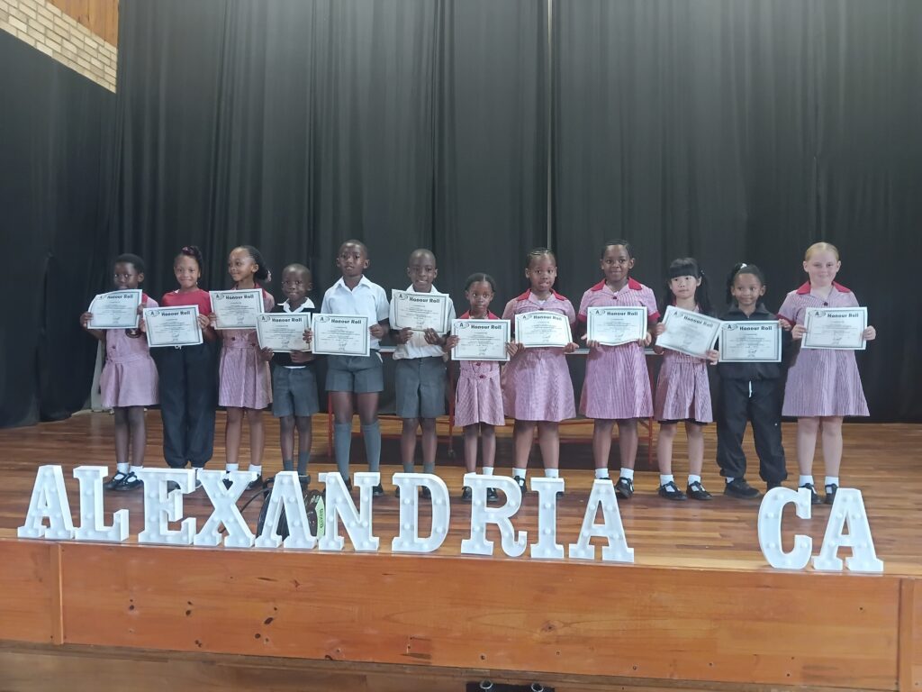Grade 2 and 3 students proudly displaying their Honor Roll certificates.