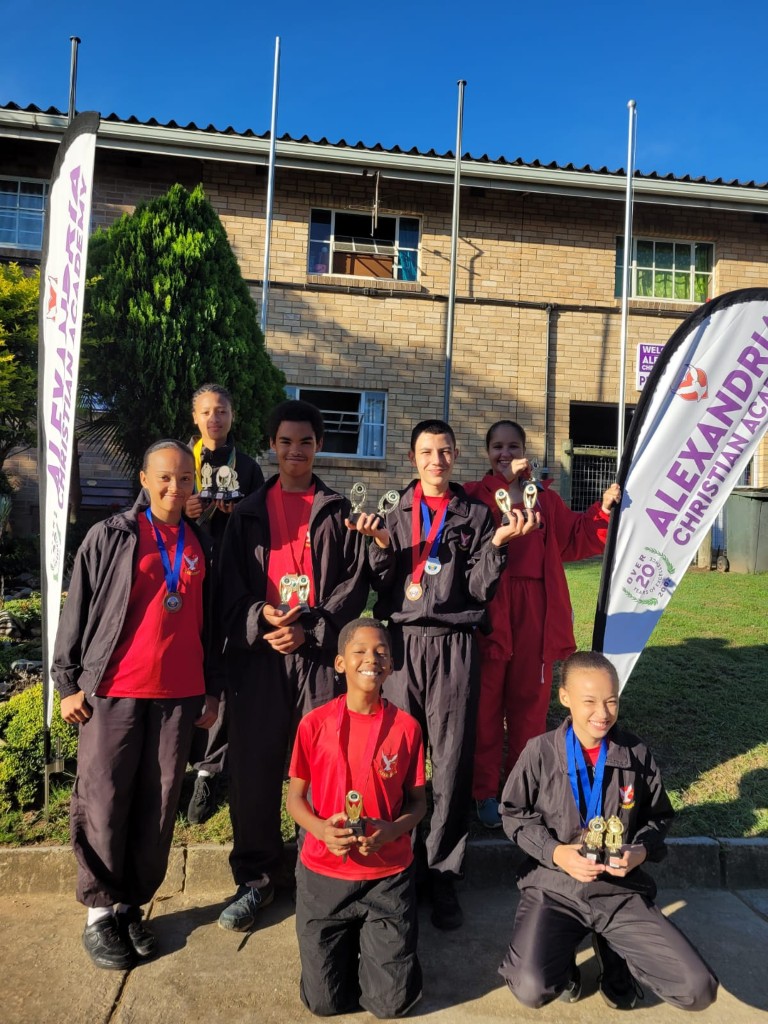 The ACA archery team displaying their medals and trophies.