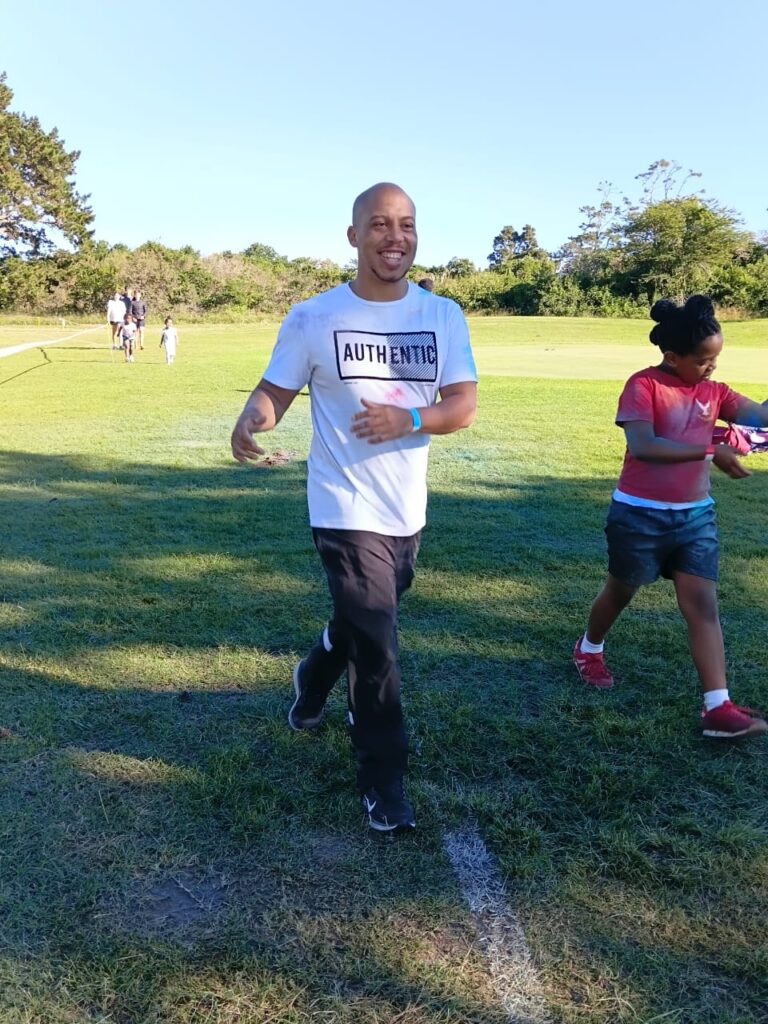 A parent enjoying the Colour Run and community fun day.