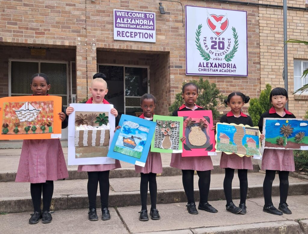 Grade 2 learners proudly showcasing their artwork.