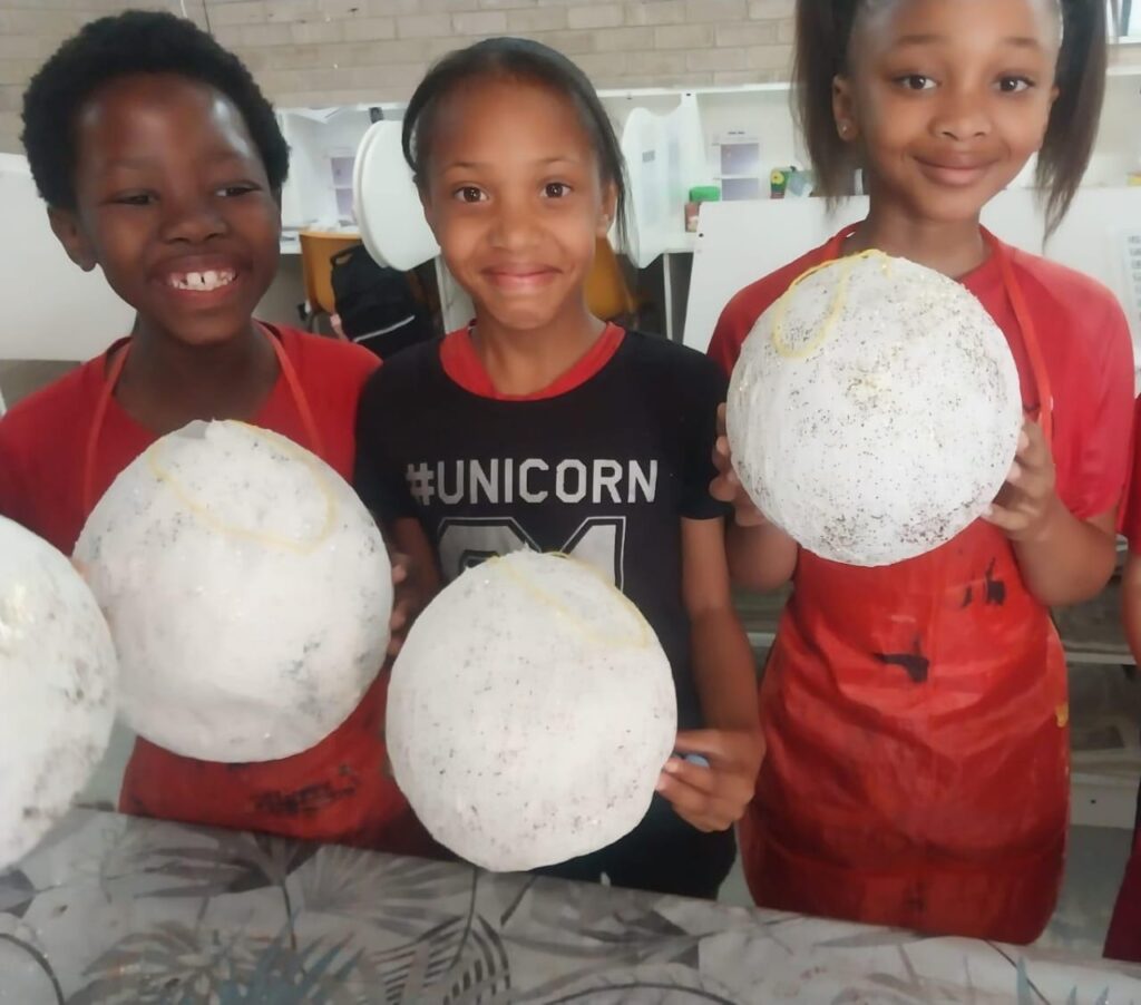 Grade 5 learners Tulani Ncanywa, Leyana Van Rooyen and Imivuyo Witbooi with their artwork.
