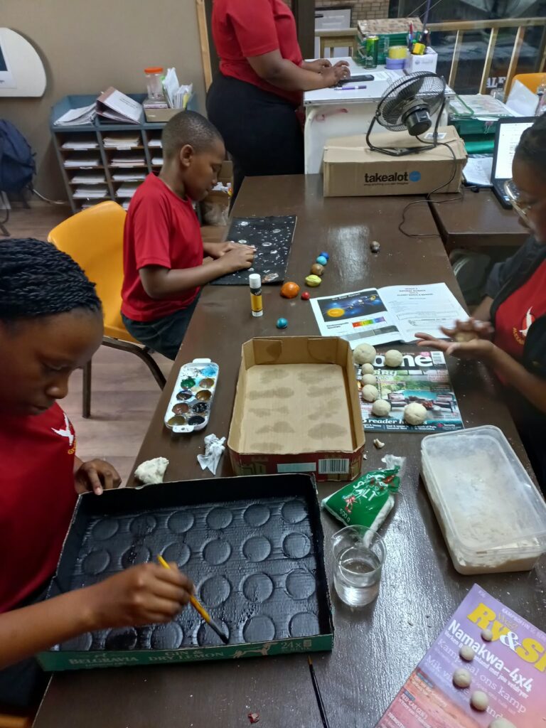 Grade 8 learners getting creative in their Science class by constructing models of the solar system.